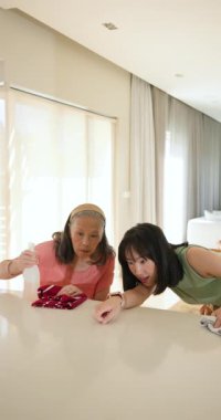 Dikey video: Mutfak tezgahını temizlemek, büyükanne ve çocuğun birlikte kaliteli zaman geçirmesi. Aile, bağ, takım çalışması, mutluluk, nesil, bakım