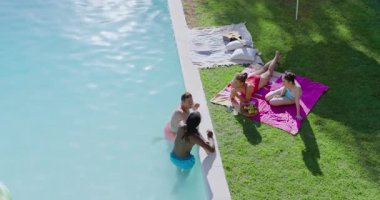 Pembe havluyla kadınları cesaretlendiren erkeklerin bilardo oynadığı çeşitli arkadaşlar kaseden meyve topluyor. Açık hava, rahatlama, rahatlama, arkadaşlık, coşku, rahatlık, sağIık.