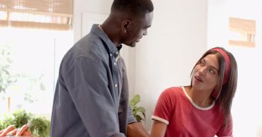 Çeşitli çiftler mutfaklarında taze portakalların tadını çıkarıyorlar, mutlu anlarını paylaşıyorlar, evde. Mutluluk, birliktelik, meyve, narenciye, yaşam tarzı