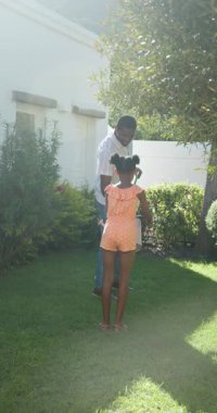 Dikey video: Anne ve kızı birlikte bahçe çiçeklerini suluyor, açık havada güneşli bir günün tadını çıkarıyorlar. Bahçıvanlık, kaynaşma, aile, doğa, ilkbahar, takım çalışması