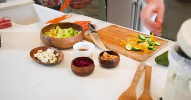 Çeşitli arkadaşlar mutfakta havuç soyarlar ve biber doğrarlar. Tablet tarifi kullanır, salata yaparlar. Aşçılık, işbirliği, sağlık, modern, enerjik, mutfak donanımı, takım çalışması