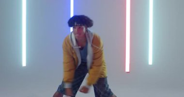 Stüdyoda yüksek oranda basketbol topu tutan Afrikalı Amerikalı adam neon tüplerle top sürüyor. Spor, atletizm, kentsel, enerji, performans, dinamik, modern