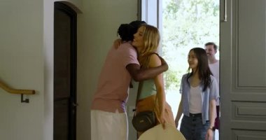 Farklı arkadaşlar Afrika kökenli Amerikalı ev sahibini takip ediyor kapıyı açıyor ve şömineyi keşfediyorlar. Misafirperverlik, misafirperverlik, gelişigüzel, modern, konuşkan, iç mekan, yaşam tarzı