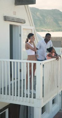 Dikey video: Aile tatilde balkondan manzaralı dağ manzarası seyrediyor, rahatlamış hissediyor. Tatil, aile zamanı, rahatlama, turizm, doğa, manzara