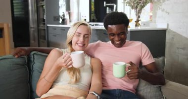 Çift kanepeye kurulup açık mutfak kadehlerini kaldırıyor, kahvelerini yudumluyor, sohbet ediyor ve gülüyor. Romantik, samimi, modern, samimi, samimi, yaşam tarzı, ev