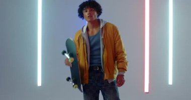 Minimum stüdyo neon tüpleri aktif, kaykayın üstüne çıkan adam, kaldırma ve teftiş güvertesi. Kentsel, dinamik, enerjik, spor, gençlik, enerji, gece hayatı