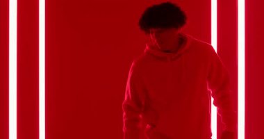 Yirmili yaşlarda bir adam klasik müzik kutusunu kontrol ediyor. Kırmızı sette LED tüplerle hoparlörleri kontrol ediyor. Retro, kentsel, çağdaş, canlı, nostaljik, izolasyon, teknoloji