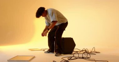 İçeri girer girmez, Afro-Amerikalı adam hoparlöre doğru yürüyor, oturuyor, panele dokunuyor ve stüdyoya bakıyor. Stüdyo, minimalizm, ses, ışıklandırma, teknoloji, iç mekan, rahatlama