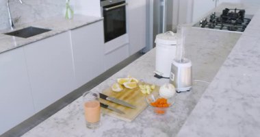 Limon dilimleri, bıçaklı kesme tahtasında dinlenen havuçlar, kase, mermer tezgahta blender. Mutfak, tezgah, hazırlık, yemek, malzemeler, modern, sağlıklı