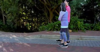 Asyalı anne ve kızı bahçede ellerinde su şişesiyle yürüyorlar. Yaşlılar bitkiyi işaret ediyorlar. Açık hava, arkadaşlık, doğa, eğlence, aile, huzur, botanik