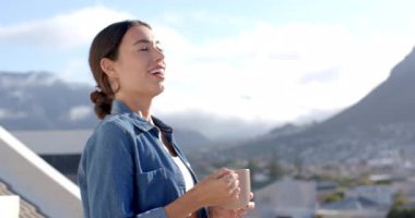 Balkonda sabah kahvesini içen genç bir kadın, huzurlu dağ manzarasını kucaklayan, fotokopi çeken. Rahatlama, sükunet, doğa, dinginlik, yaşam tarzı, rahatlık