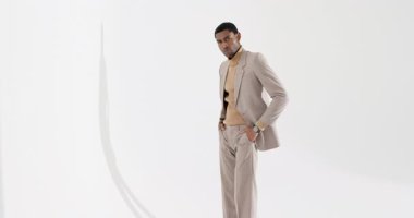 30 'lu yaşlarda Afro-Amerikalı bir adam stüdyo kontrol saatinde balıkçı yaka kazağının üzerinden takım elbise ayarlıyor. Profesyonel, moda, minimalizm, zarafet, tarz, sofistike, iş