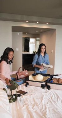 Dikey video: Yolculuktan önce bayan arkadaşlar süitte bavul hazırlar, şapka, kitapçık ve üstleri ayırırlar. Seyahat, arkadaşlık, günlük, yaşam tarzı, hazırlık, organizasyon, dikey video