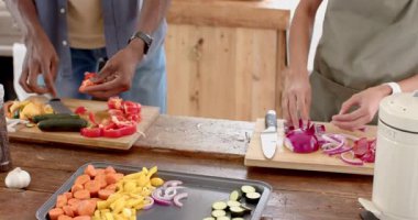 Çeşitli çiftler mutfakta birlikte yemek pişiriyor, tatilin tadını çıkarıyor, evde. Beraberlik, eğlence, aşçılık, yaşam tarzı, farklı çiftler, mutluluk.