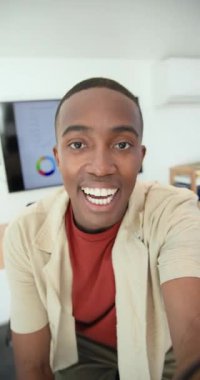 Vertical video: African American man teaching chart trends at home while recording on smartphone. Business, analysis, data, technology, education, communication, vertical video