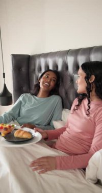Dikey video: Sabah gülüşleri tepsiyi paylaşan, meyve suyunu yudumlayan, yatakta sohbet eden iki kadını ateşliyor. Samimiyet, arkadaşlık, rahatlama, konforlu, sevgi dolu, sağlıklı yaşam tarzı, dikey video