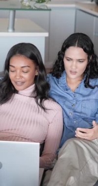 Dikey video: Kanepe başı, beşlik çakma ve kucaklaşmadan dizüstü bilgisayara odaklanan çeşitli kadınlar. İlişki, yakınlık, yakınlık, arkadaşlık, rahatlama, arkadaşlık, dikey video