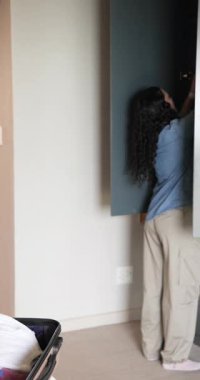 Dikey video: Çeşitli kadın arkadaşlar evde mayo bavulu hazırlayıp seyahat planlaması yapıyorlar. Röntgenci, yaşam tarzı, rahat, rahat, arkadaşlık, dikey video