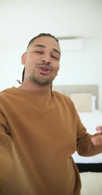 Dikey video: Kamerayı açmak, erkek yaratıcı yatak odasında tura başlıyor, yatak çeviriyor, kapanıyor. Vlog, gündelik, minimalizm, yaşam tarzı, iç mekan, ev, dikey video