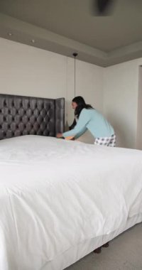 Dikey video: pijamalı Afro-Amerikalı arkadaşlar evde yastık kavgası yapıyor. Dost canlısı, rahat, rahat, neşeli, rahat, eğlenceli, dikey video