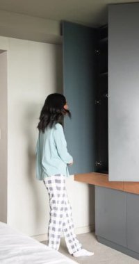 Dikey video: Kadın yatak odasına giriyor, gardırobu açıyor, yeşil bluzu ve geceliği kapıyor. Giyim, gardırop, organizasyon, yaşam tarzı, günlük, iç mekan, dikey video