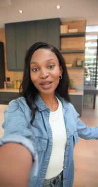 Dikey video: Kayıt başlıyor Afrikalı Amerikalı kadın film çekiyor mutfak adasında öpüşüyor. Yaşam tarzı, yerli, yaşam tarzı fotoğrafı, yaşam tarzı fotoğrafı, ev, iç mekan, dikey video