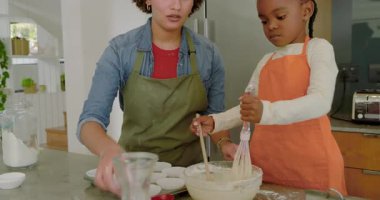 Kek tepsisi doldurmak ve hamuru çırpmak için farklı annelere rehberlik etmek. Aile, akıl hocalığı, işbirliği, hazırlık, yerli, erdemli, sanatsal