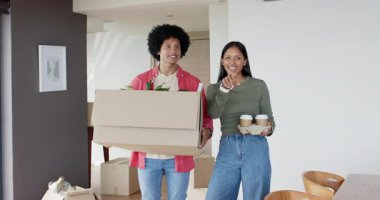 Çeşitli çiftler kutuları ve kahve fincanlarını taşıyorlar, yeni evlerine yerleşirken bitki yerleştirmeyi yönetiyorlar. Ev idaresi, yer değiştirme, takım çalışması, günlük, modern, neşeli, iç mekan.