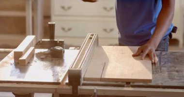 Afro-Amerikalı bir adam atölye tezgahında tahta keski kullanıyor, klemp saplı, kopyalama alanı var. Zanaatkar, marangoz, el yapımı, rustik, zanaatkar, atölye, işçilik