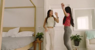 Neşeli pisti takip eden çeşitli bayan arkadaşlar, parlak yatak odasında tente ve aynanın yanında dans ediyorlar. Dans, arkadaşlık, yaşam tarzı, canlı, neşeli, sağlıklı, hareketli