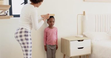 Farklı anne ve çocuklar yatak odalarında boylarını kitap, kalem, sarılma ve kopyalama alanlarını kullanarak ölçüyorlar. Aile, bağ, çocukluk, büyüme, eğitim, konfor, beslenme