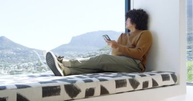 Pencere kenarında iki adam, biri akıllı telefondan kayıyor diğeri de vadiye girip sarılıyor. Çağdaş, kentsel, sakin, samimi, bağlantı, barışçıl, yaşam tarzı