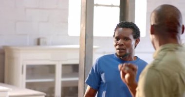 Afrika kökenli Amerikalı erkek meslektaşların kulaklıklar ve dolaplarla atölyeyi incelemesi. Endüstriyel, takım çalışması, işçilik, inşaat, işbirliği, eğitim, meslek