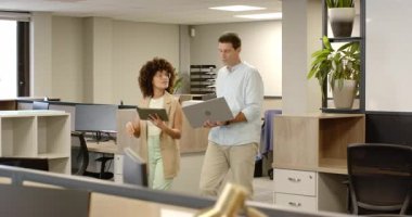 Çeşitli iş arkadaşları Bölücü Buharlı Tablet ve Laptop karşılaştırmasında durup beşliği kutluyorlar. İşbirliği, takım çalışması, yenilik, dijital, modern, üretkenlik, iletişim