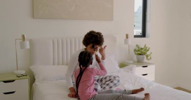 Çocuk, çeşitli anne ve kızlarının yatak kaynaşmasına öncülük eden fırça karıştırıyor. Aile, bağ, yakınlık, beslenme, oyun, şefkat, yaşam tarzı