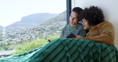 Açılış kitabı, iki adamı battaniyeli bankta akıllı telefonu paylaşmaya ve pencere manzarasına doğru eğilmeye götürüyor. Samimi, dostluk, rahatlama, yaşam tarzı, iç mekan, sıcak, huzur