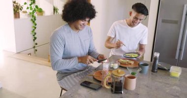 Mutfak adasında oturan çeşitli erkekler kahvaltıya avokado tostu yumurta ve kahveyle başlıyorlar. Arkadaşlar, kahvaltı, modern, yaşam tarzı, samimi, aşçı, sosyal