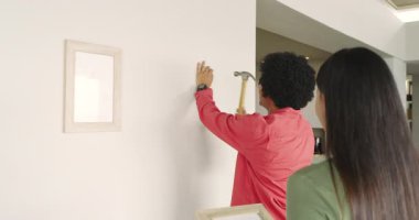 Çeşit çeşit çift evdeki duvarların çerçevelerini değiştiriyor, kancaları çekiçliyor ve mezurayla ölçüyorlar. İç mekan, yenileme, işbirliği, minimalizm, uyum, işçilik, yaşam tarzı