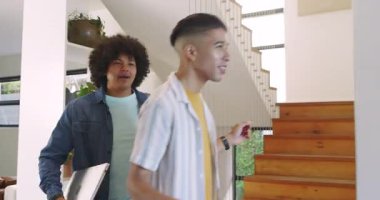 Çeşitli erkek arkadaşlar mutfağa giriyor, poşetlerdeki meyveleri açıyor, domates yiyor ve gülüyorlar. Günlük, dostane, yaşam tarzı, canlı, modern, sosyal, taze üretim