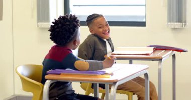 Sınıfta gülen ve konuşan çok ırklı çocuklar, birlikte öğrenmenin tadını çıkarıyorlar. Eğitim, çok ırklı çocuklar, arkadaşlık, takım çalışması, işbirliği