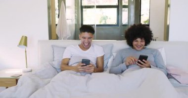 Çeşitli erkek partnerler akıllı telefonu eğip evde komik içeriği, kaydırmayı ve gülmeyi paylaşıyorlar. Samimiyet, bağlantı, rahatlık, rahatlama, sıcaklık, uyum, arkadaşlık.