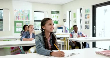 Okulda, çok ırklı öğrenciler sınıfta hevesle el kaldırıyor, derslere giriyorlar. Eğitim, öğrenim, katılım, öğretim, akademik, katılım