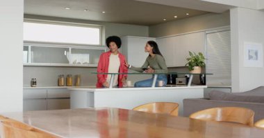 Çeşitli çiftler telefonları kaydırıyor, teslimattan sonra market kutularını açıyor ve adada yemek hazırlıyorlar. Aile, aile, yaşam tarzı, modern, samimi, etkileşim, ev