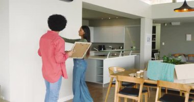 Çerçeveyi eve taşıyorlar. Çeşitli çiftler, kutlama yapmak için çivi çakıyorlar ve dans ediyorlar. Modern, samimi, neşeli, yenileme, arkadaşlık, iç mekan, yürekten.