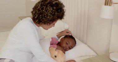 Anne telefonda çocuğun semptomlarını kontrol ediyor. Yatak odasındaki termometreye göre ateşini ölçüyor. Kopya odası. Bakıcı, yetiştirme, konfor, sağlık, aile, güven, yurtiçi