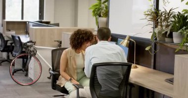 Çeşitli iş arkadaşları laptoplarını kullanarak ve iş arkadaşları üzerine rapor vererek masa başı iş birliği yapıyorlar. İşbirliği, profesyonellik, takım çalışması, modernlik, üretkenlik, iletişim, yenilik