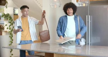 Çeşitli erkek arkadaşlar mutfak adasında meraklı, gözetleyen ve akıllı telefonu paylaşan kişiler. İşbirliği, yoldaşlık, modern, enerjik, teknoloji, yaşam tarzı, eğlence