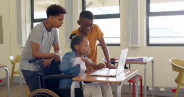 Sınıfta dizüstü bilgisayar kullanan, gülümseyen ve okulda öğrenmekle meşgul çok ırklı öğrenciler. takım çalışması, eğitim, teknoloji, işbirliği, okul