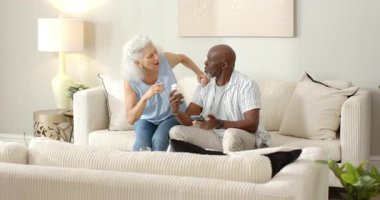 Akıllı telefon başında el kol hareketi yapan ve kanepede ilaç şişesini inceleyen yaşlı çiftler dozajı tartışıyorlar. Yaşlılar, teknoloji, iletişim, sağlık, samimiyet, refah, aşinalık