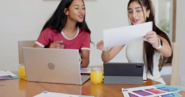 Çeşitli bayan arkadaşlar dizüstü bilgisayarı açıp tableti ayarlıyorlar, yemek masasında kumaş parçalarıyla dizayn ediyorlar. İşbirliği, yaratıcılık, takım çalışması, çalışma alanı, modern, canlı, yenilik